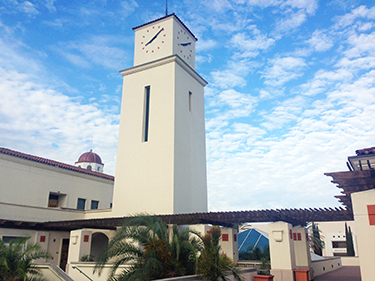 photo: clock tower 2nd level of student services west with blue sky and clouds
