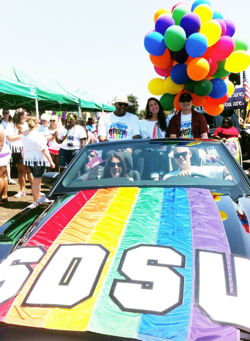 Photo: Students in SDSU car with rainbow balloons in Pride Parade