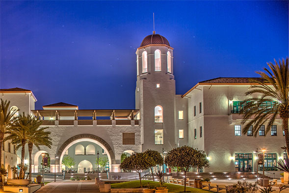 night time photo of conrad prebys aztec student union with glowing lights
