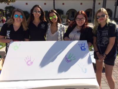 students displaying a board of handprints