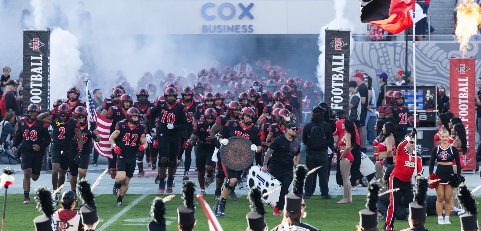 photo of footbal team running through tunnel