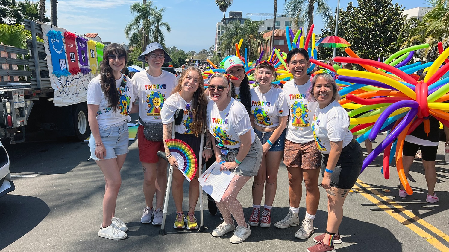 group of people on street at San Diego pride festival and balloons in the background