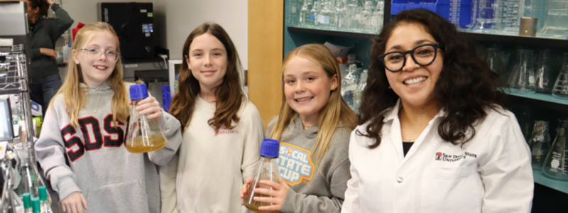 Professor Cristal Zuniga poses with fifth grade students from Fletcher Hills Elementary
