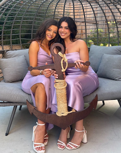 Members of Delta Gamma smile for a photo while holding an anchor.